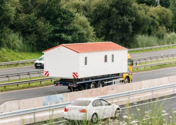 Truck on a highway carrying a prefab house